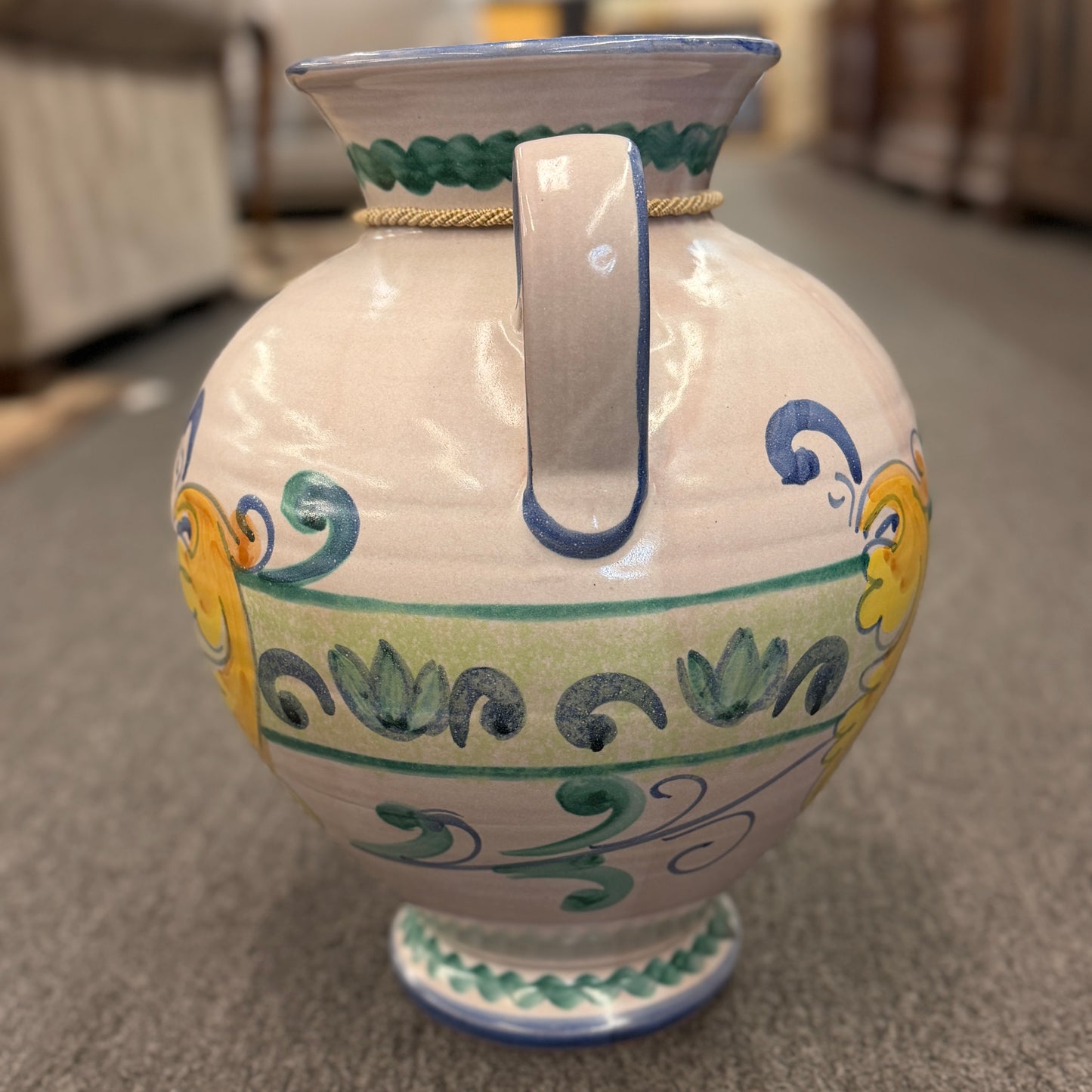 Decorative ceramic vase with colorful patterns on a carpeted floor