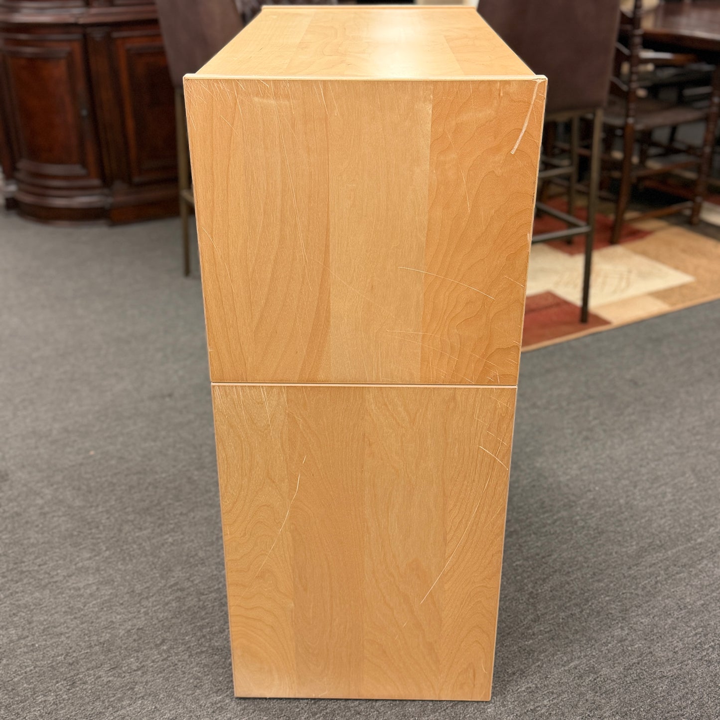 Wooden podium on a carpeted floor with chairs and furniture in the background