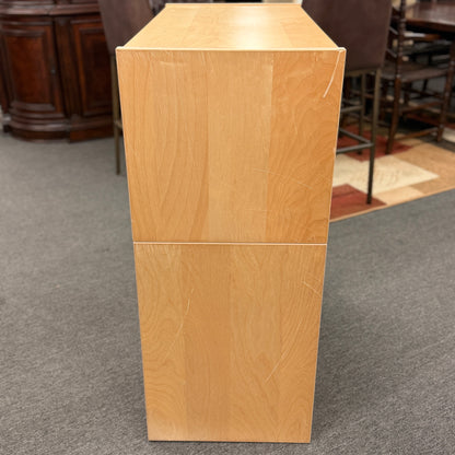 Wooden podium on a carpeted floor with chairs and furniture in the background