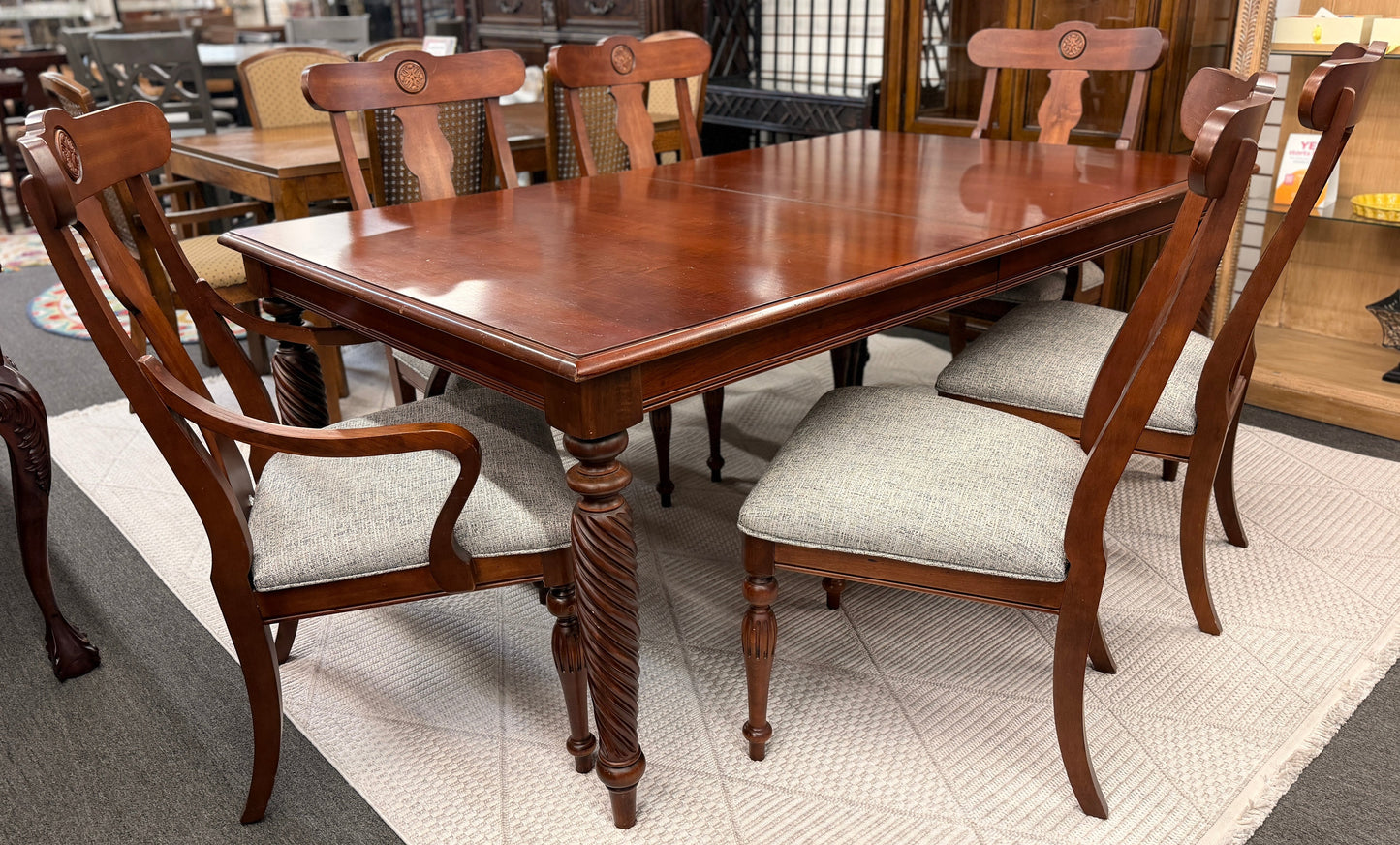 Wooden dining table with chairs in a showroom setting
