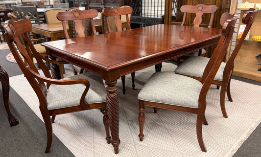 Wooden dining table with chairs in a showroom setting