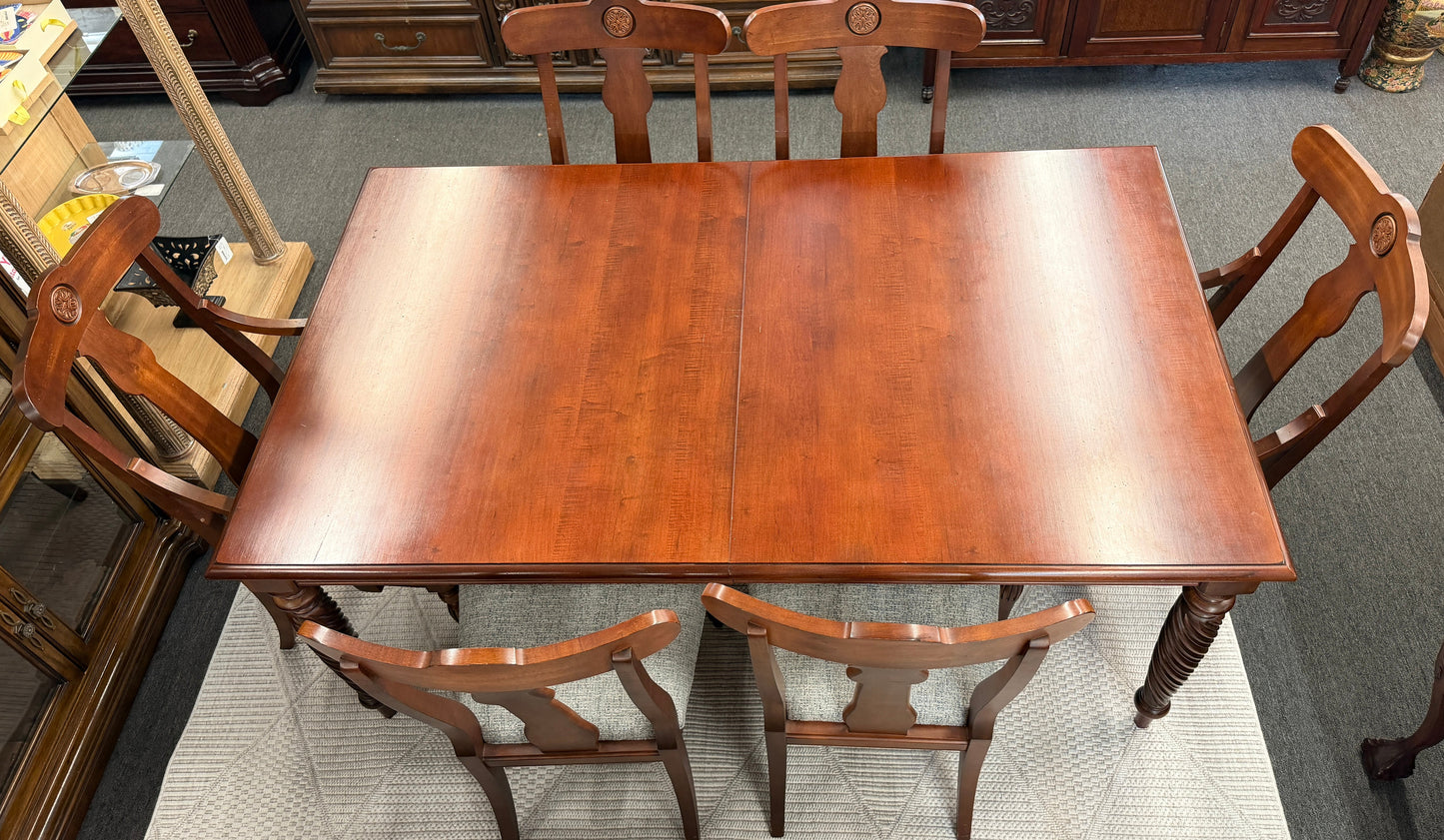 Wooden dining table with four chairs in a room setting