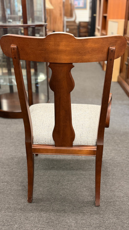 Wooden chair with a cushioned seat on a gray carpet