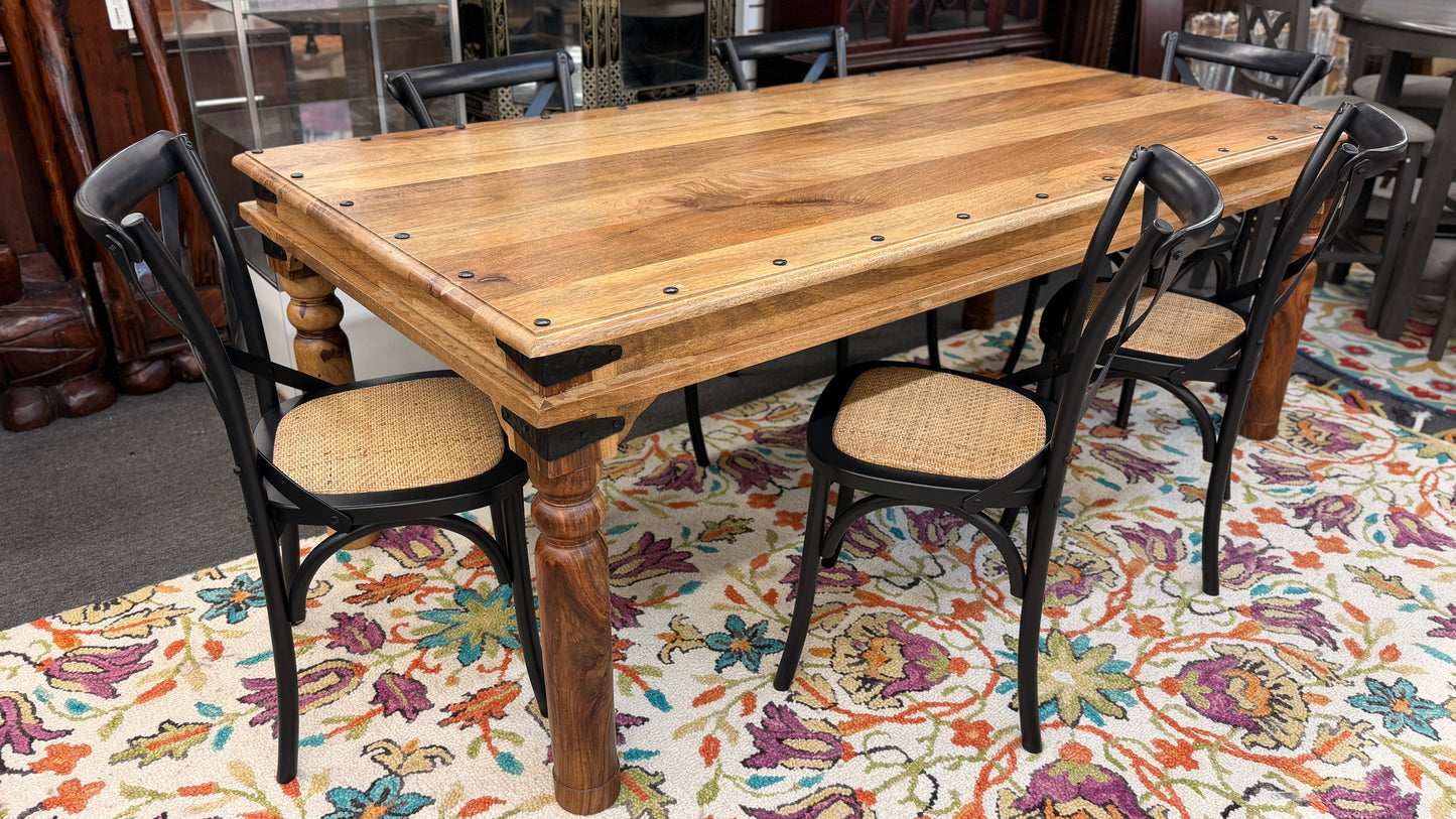 Wooden dining table with black chairs on a patterned rug