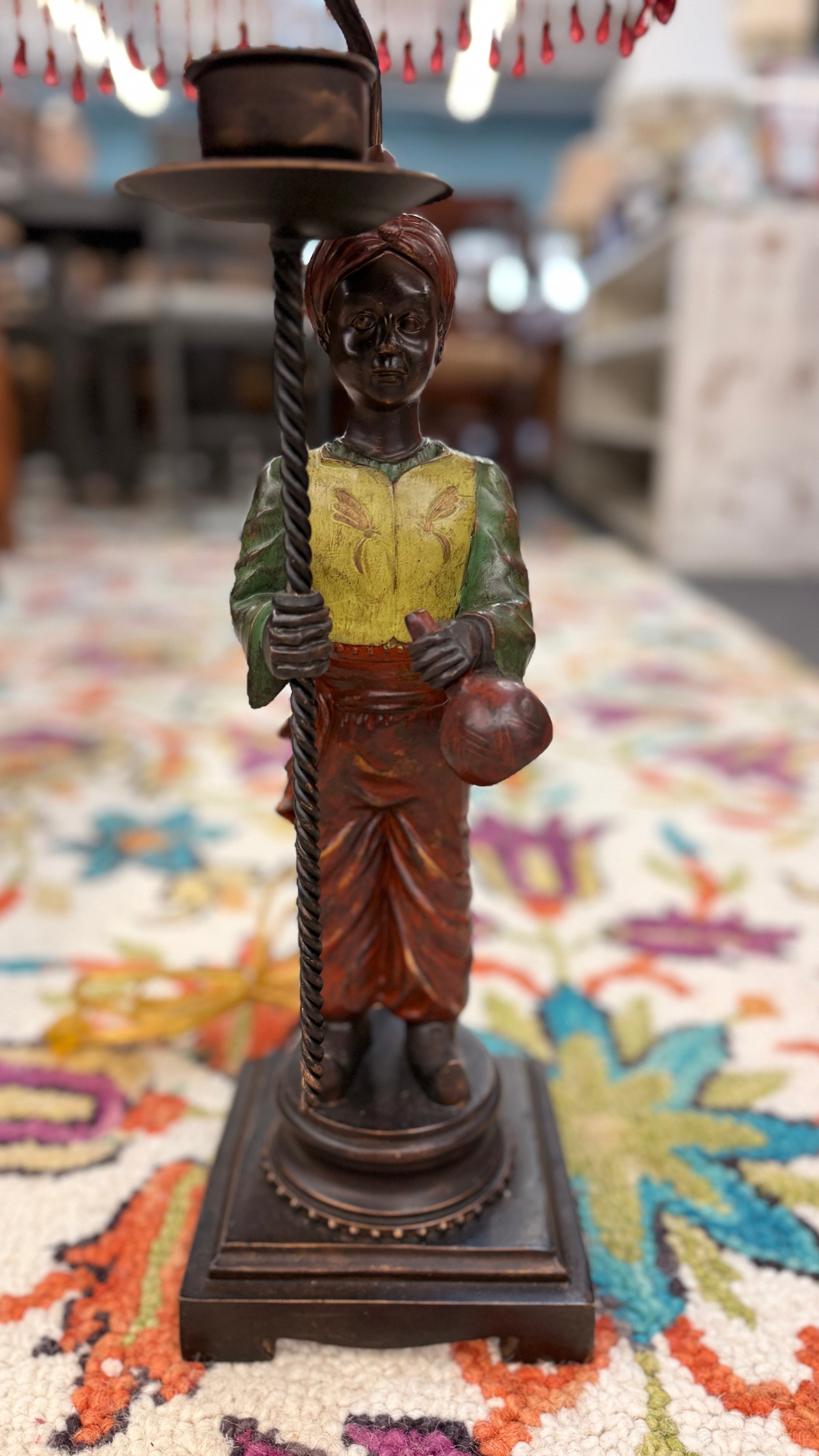 Decorative figure of a person holding a hat on a colorful rug