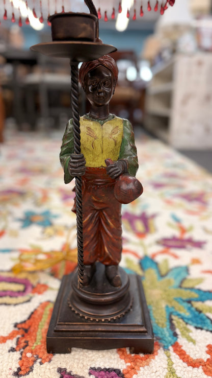 Decorative figure of a person holding a hat on a colorful rug