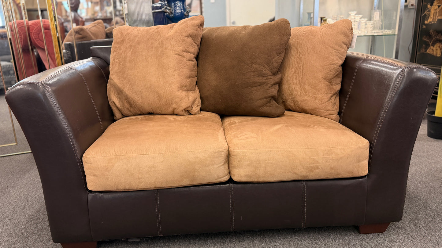 Brown sofa with beige cushions in a store setting