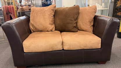 Brown sofa with beige cushions in a store setting