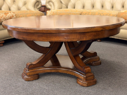 Wooden round table with a classic design in a room with upholstered furniture.