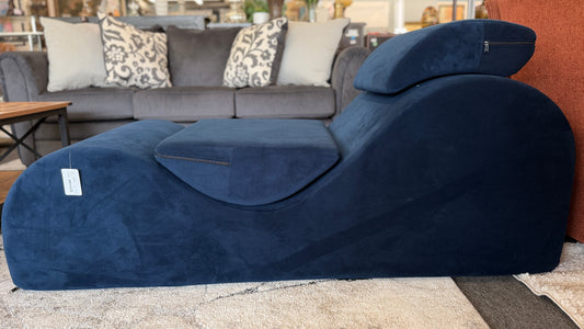 Blue chaise lounge in a living room setting with a gray sofa and patterned cushions.