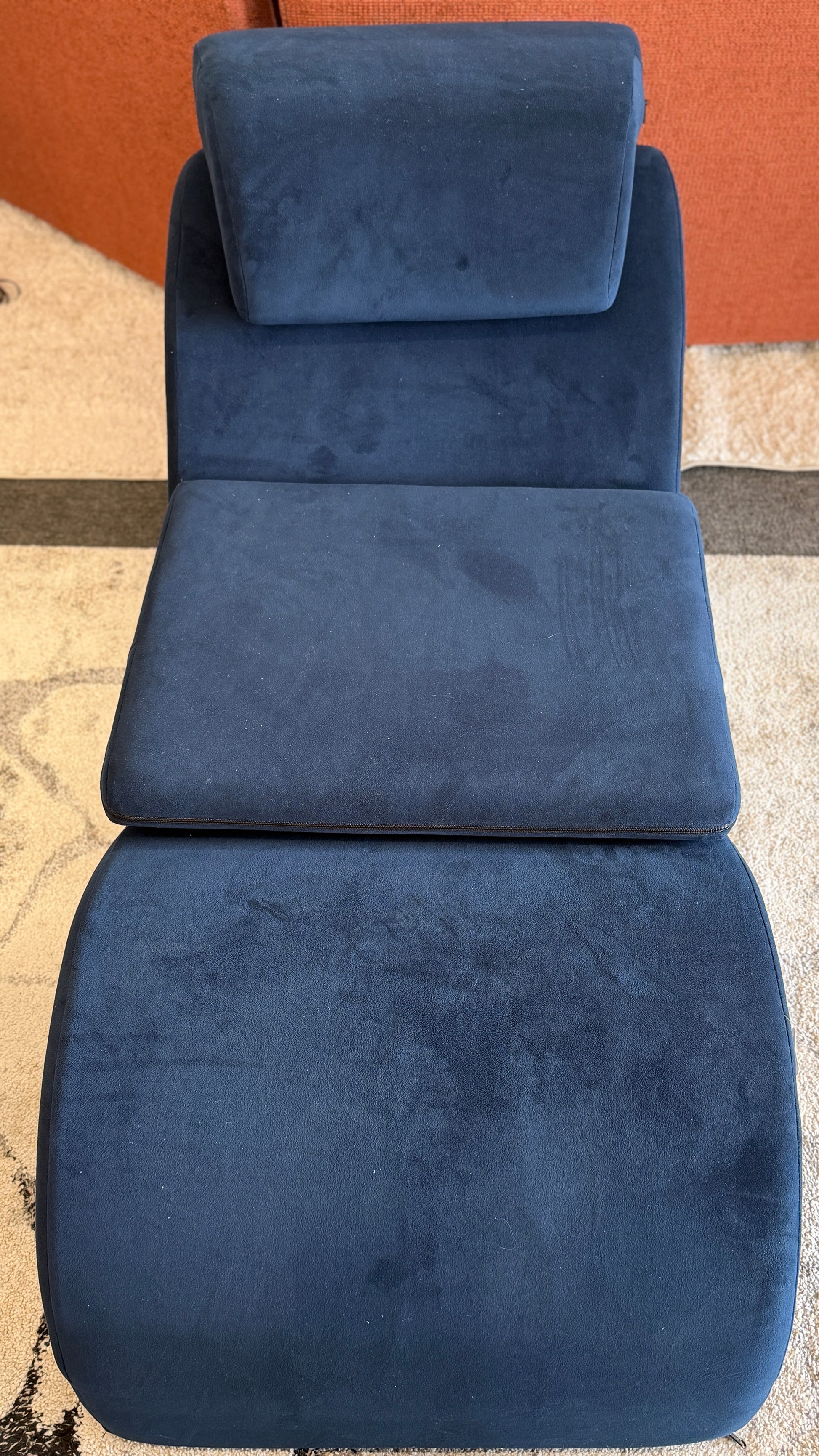 Blue massage chair pad on a textured floor