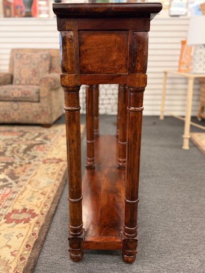 Wooden pedestal table in a room with furniture and decor.