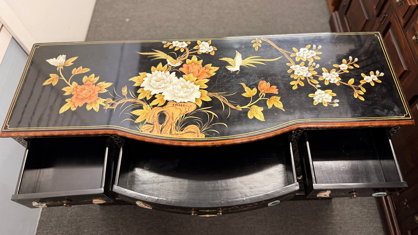 Decorative black table with floral patterns on a plain background