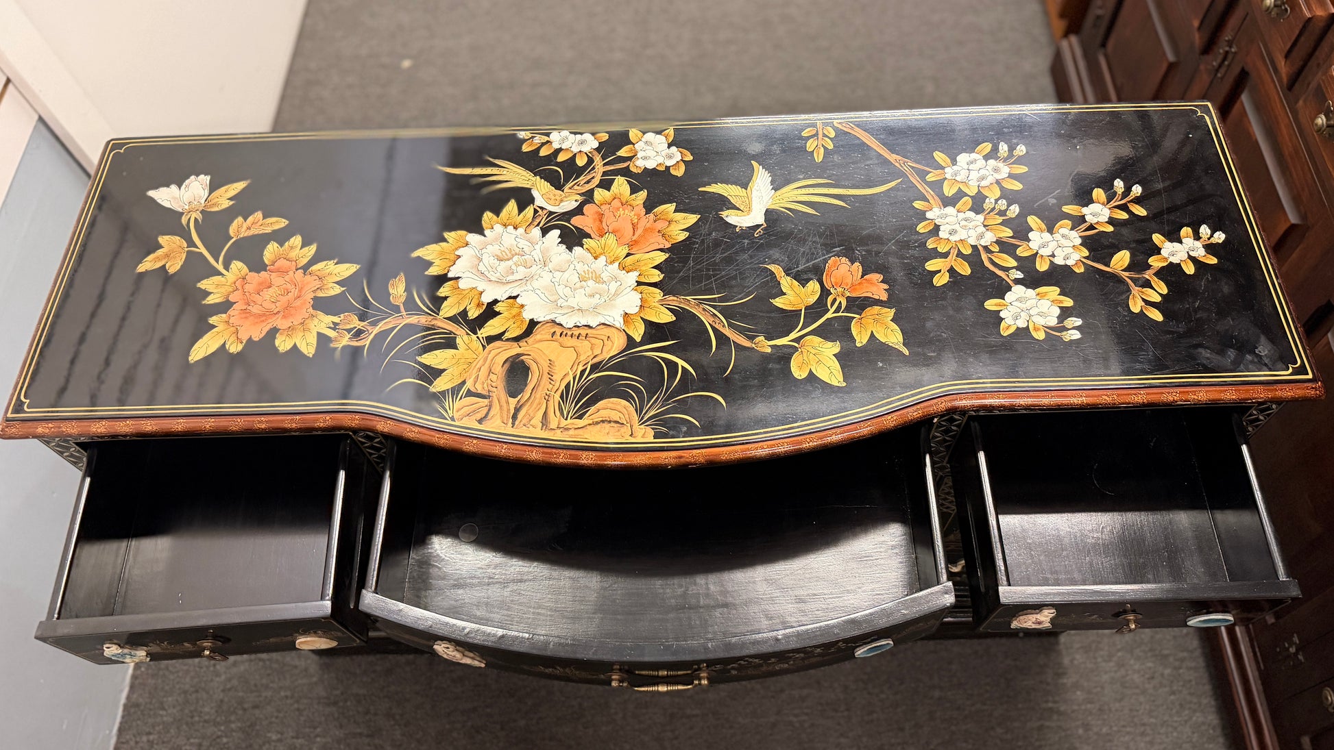 Decorative black table with floral patterns on a plain background