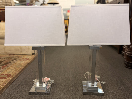 Two table lamps with white lampshades on a carpeted floor.