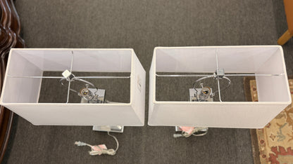 Two white rectangular boxes with hooks on a textured gray wall.