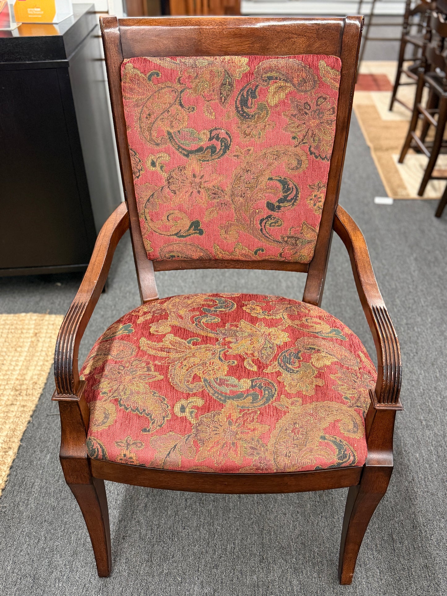 Chair with floral-patterned red fabric on a gray floor