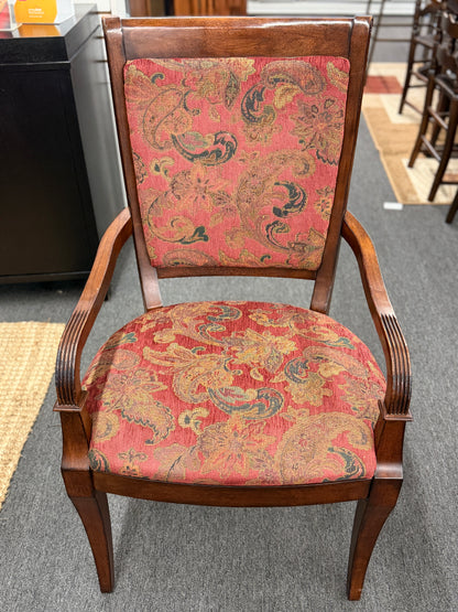 Chair with floral-patterned red fabric on a gray floor