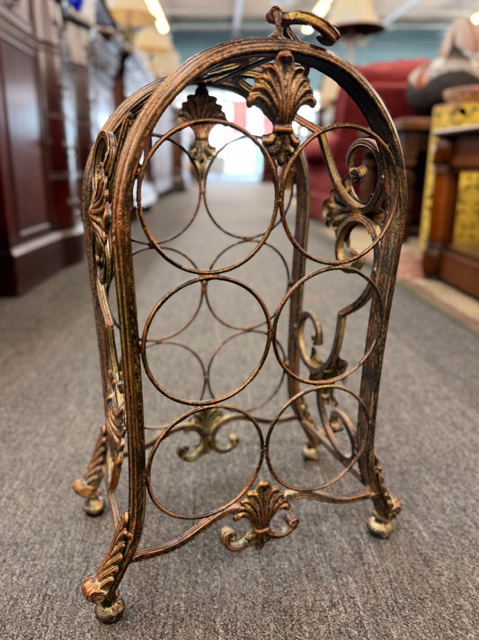 Decorative metal wine rack on a carpeted floor