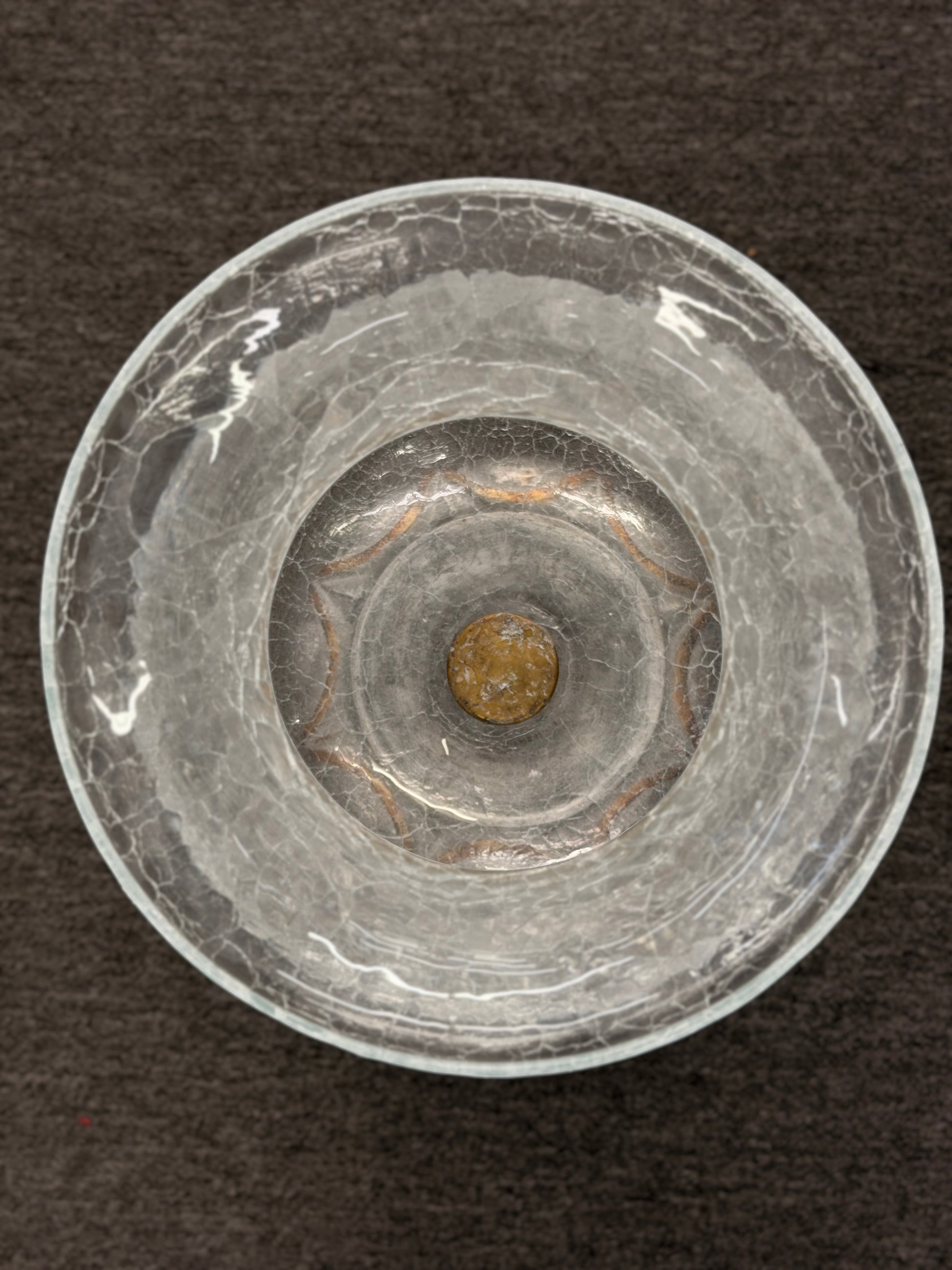 Clear glass object with concentric circles on a dark background