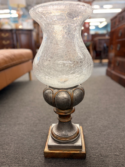 Decorative lamp with a textured glass shade on a carpeted floor