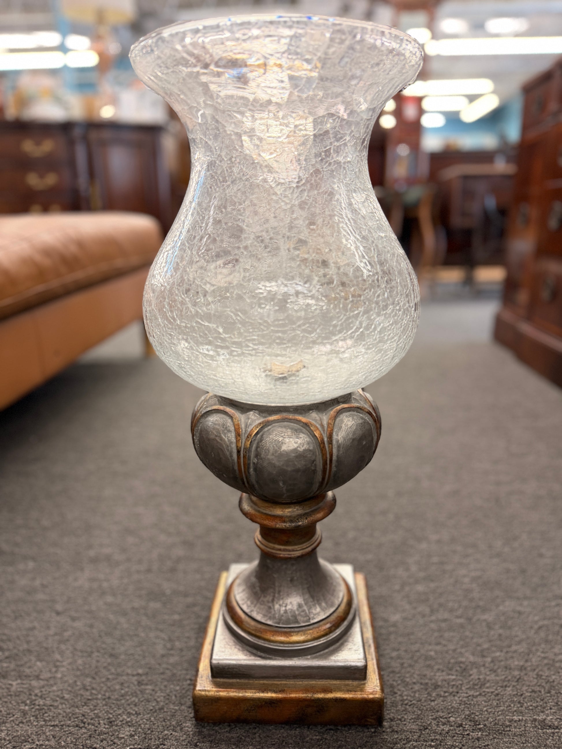 Decorative lamp with textured glass shade on a carpeted floor