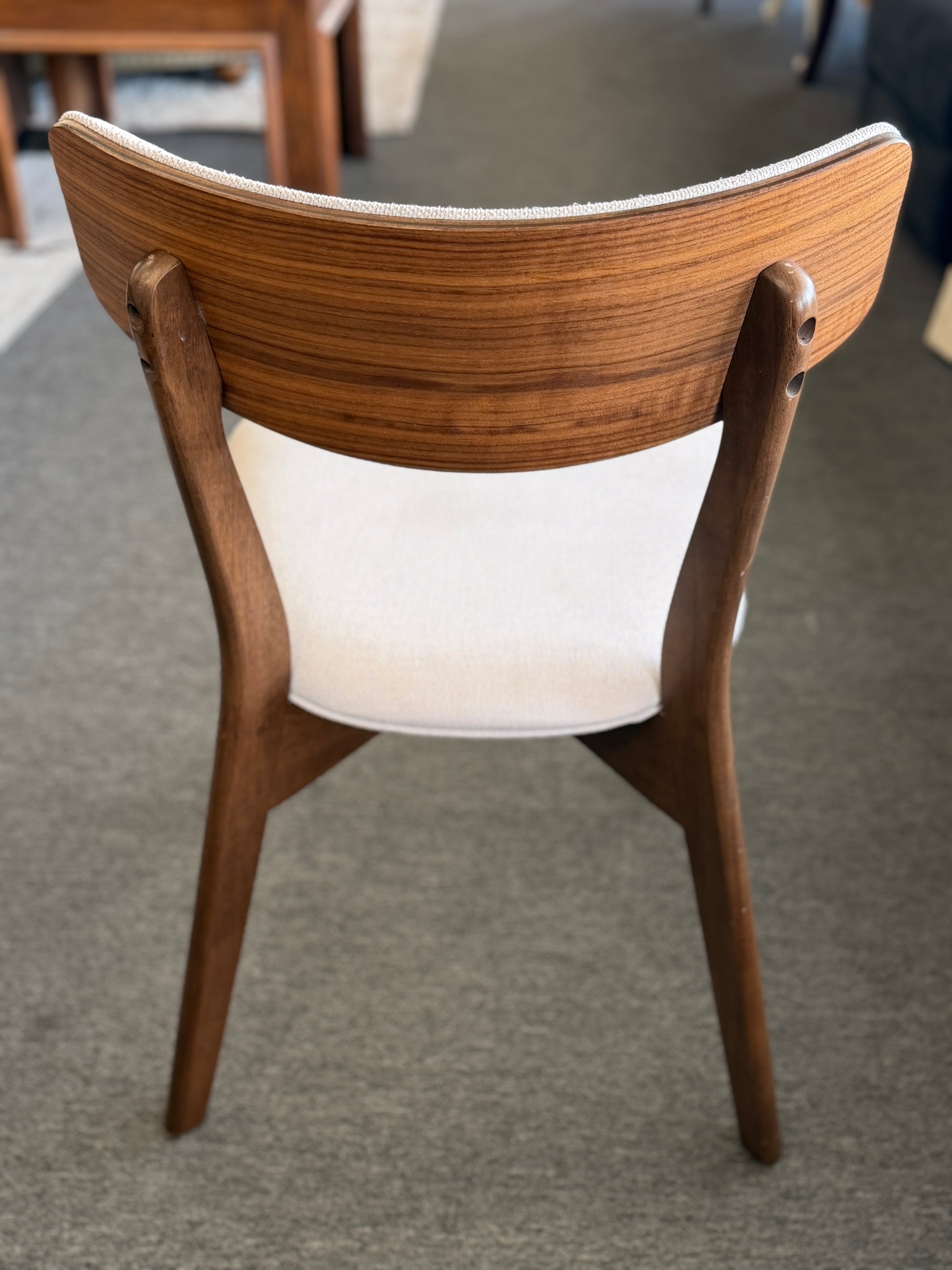 Wooden chair with a white cushion on a gray floor
