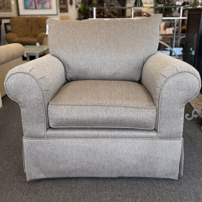 Gray armchair in a room with furniture and decor