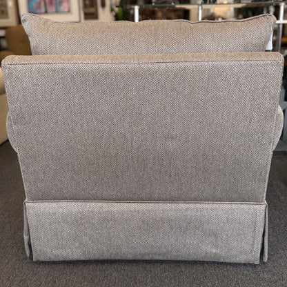 Gray upholstered headboard on a bed in a bedroom setting