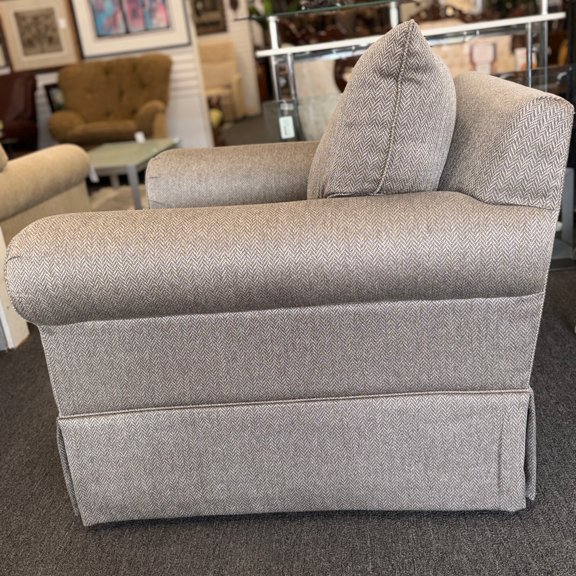 Gray upholstered chair with patterned fabric in a showroom setting