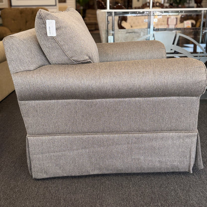 Gray upholstered chair with a patterned texture in an indoor setting