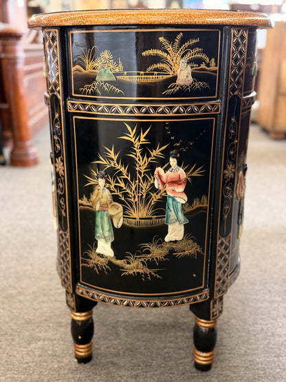 Decorative side table with black and gold chinoiserie design featuring people and landscape.