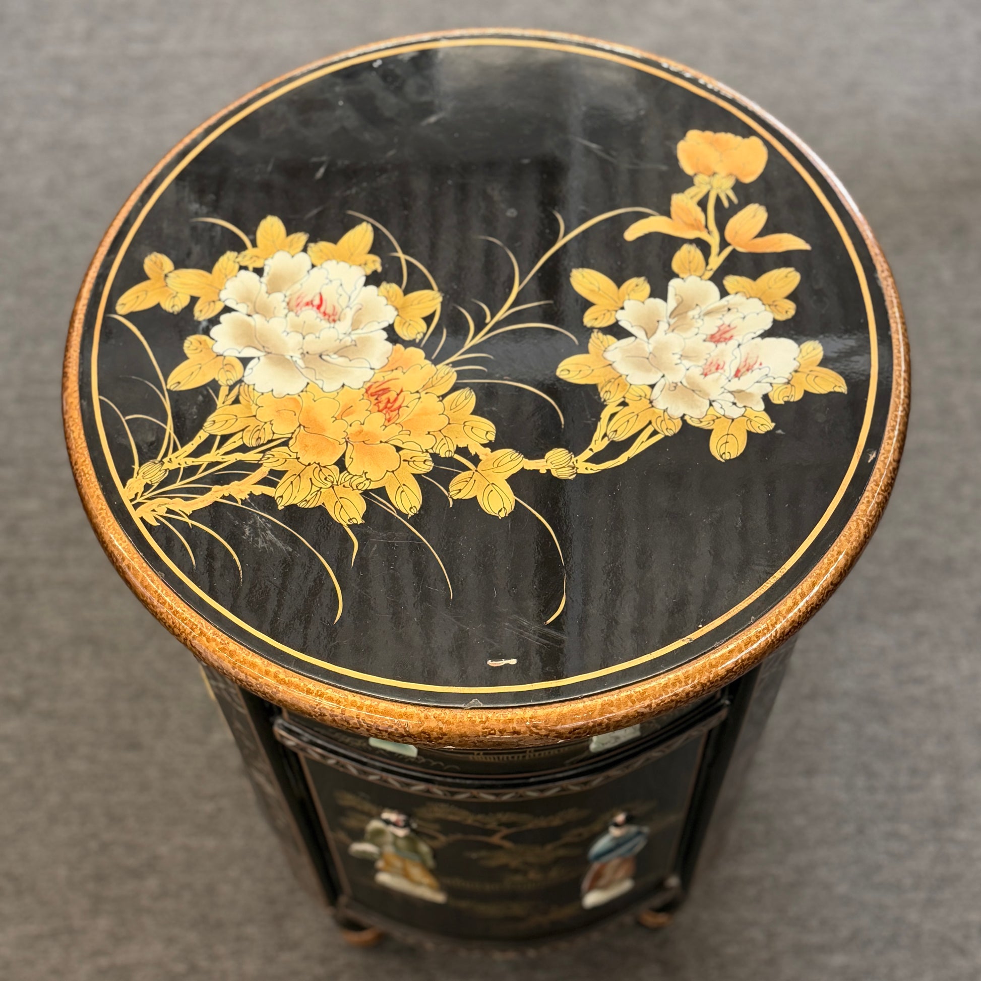 Round black table with floral designs on a gray background