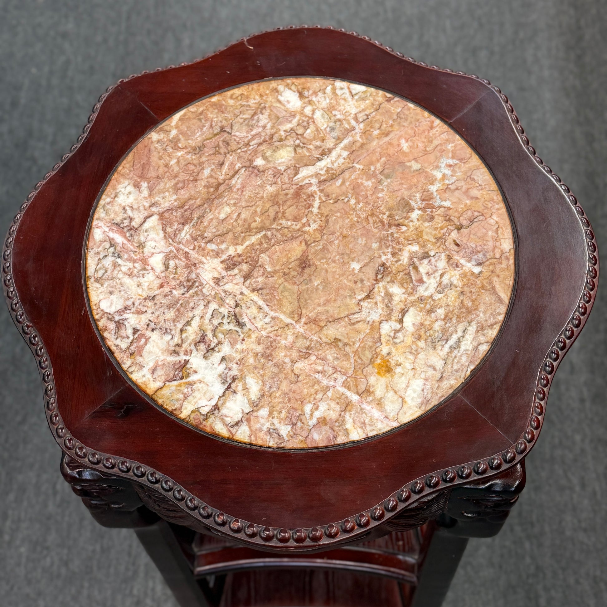 Round marble table with wooden frame on a gray background