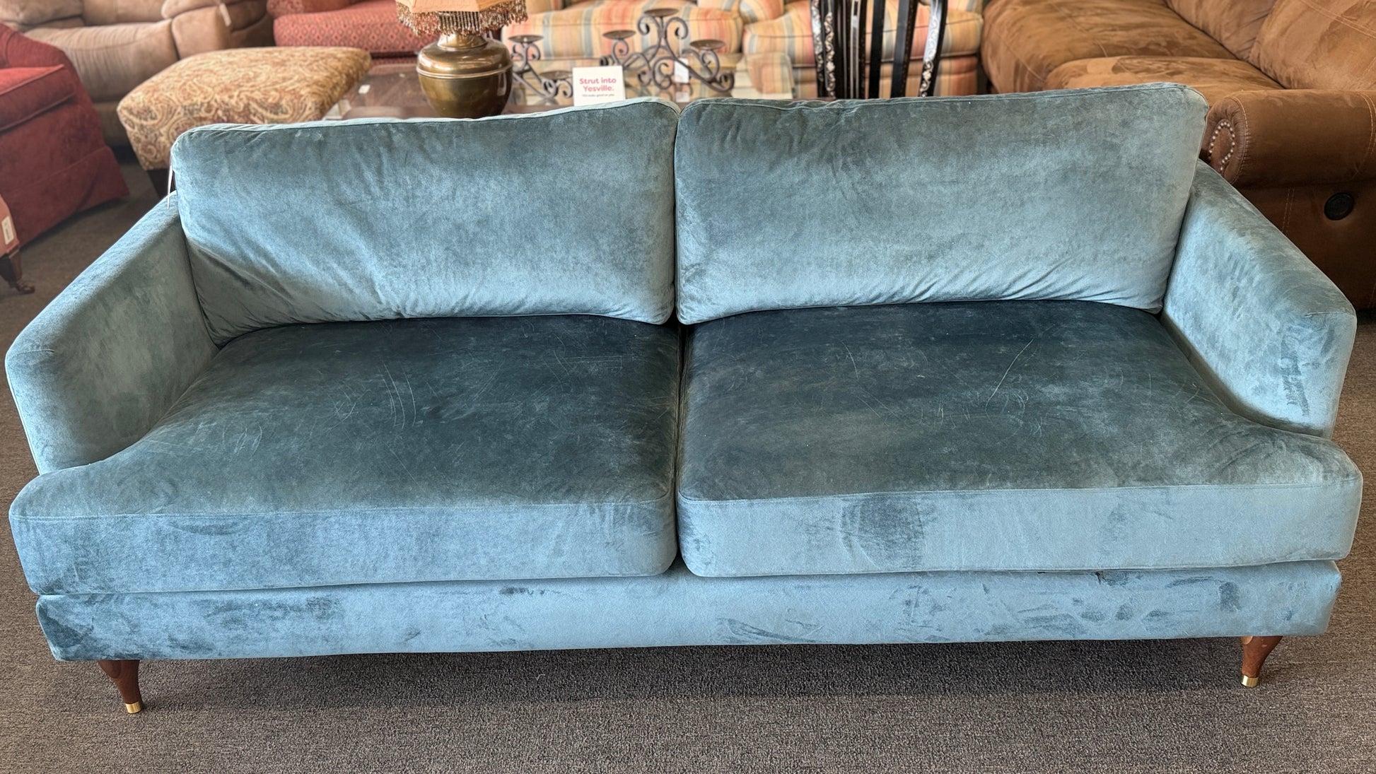 Blue velvet sofa in a room with furniture