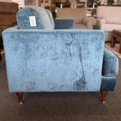 Blue armchair with a price tag in a furniture store setting