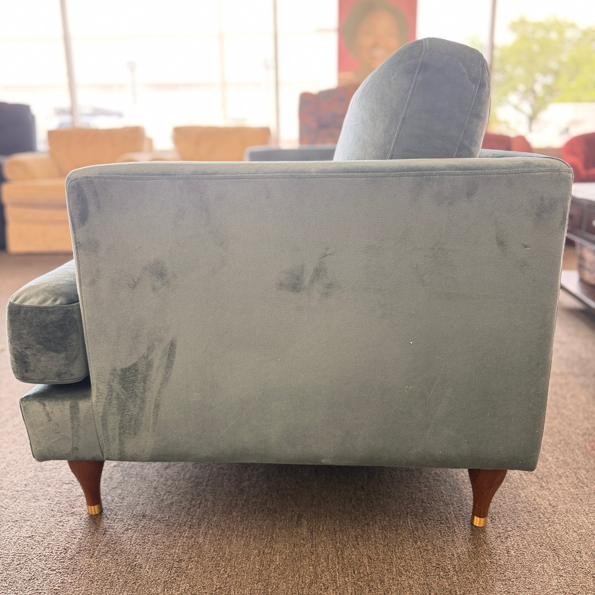 Gray armchair with visible wear and tear in a room setting
