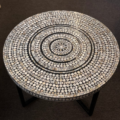 Round table with a circular mosaic pattern on a dark background