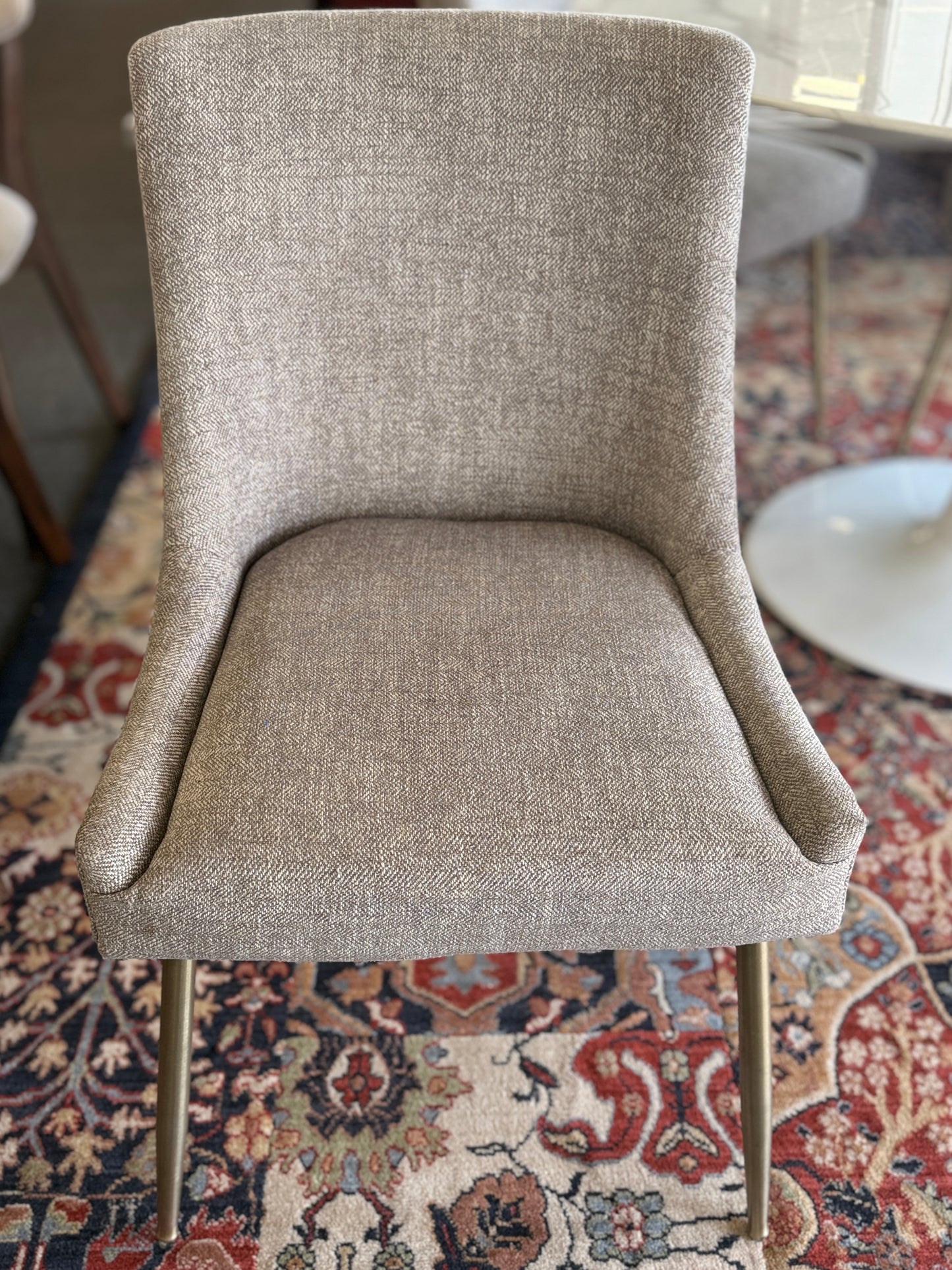Gray upholstered chair on a patterned rug