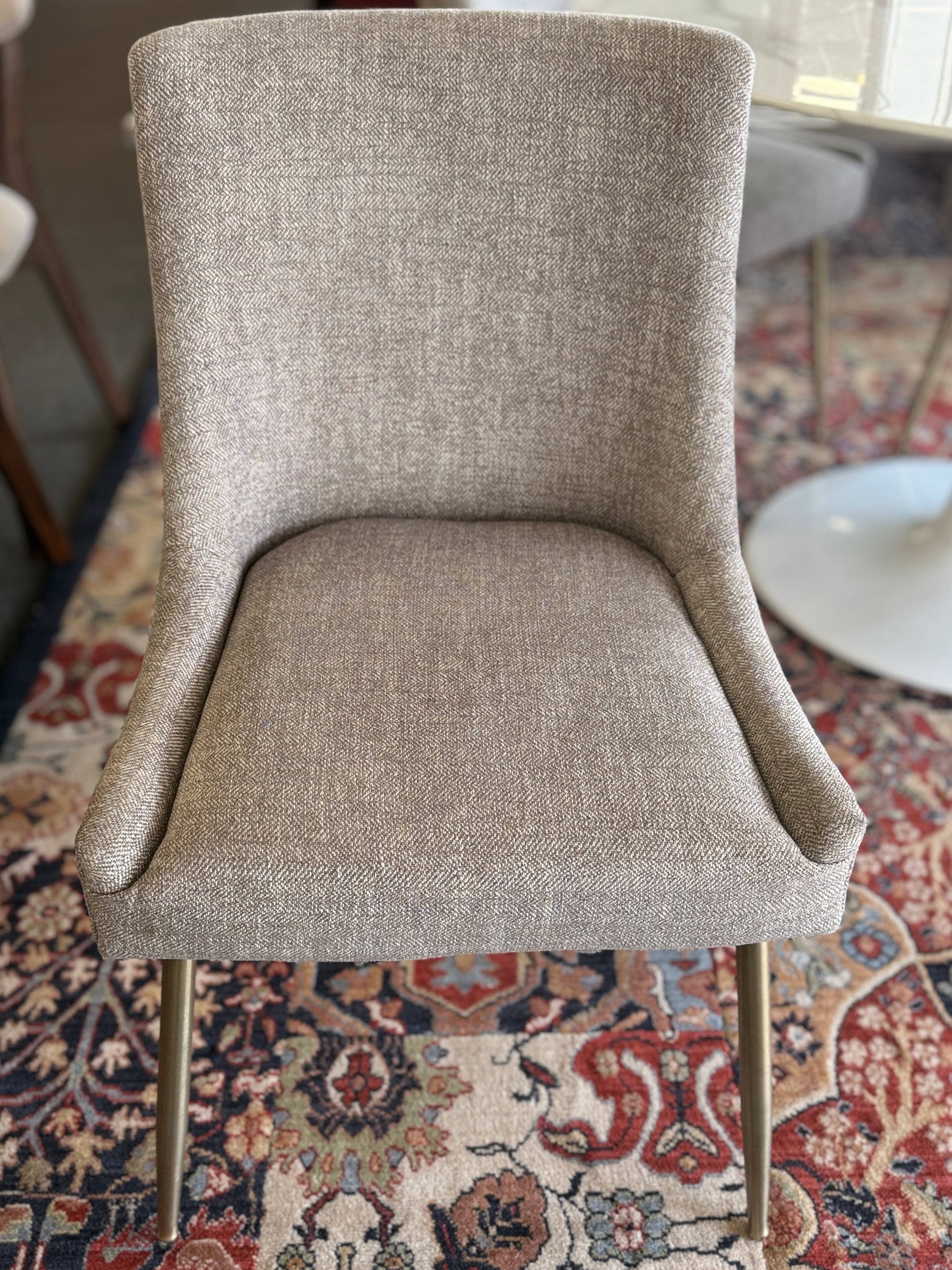 Gray upholstered chair on a patterned rug