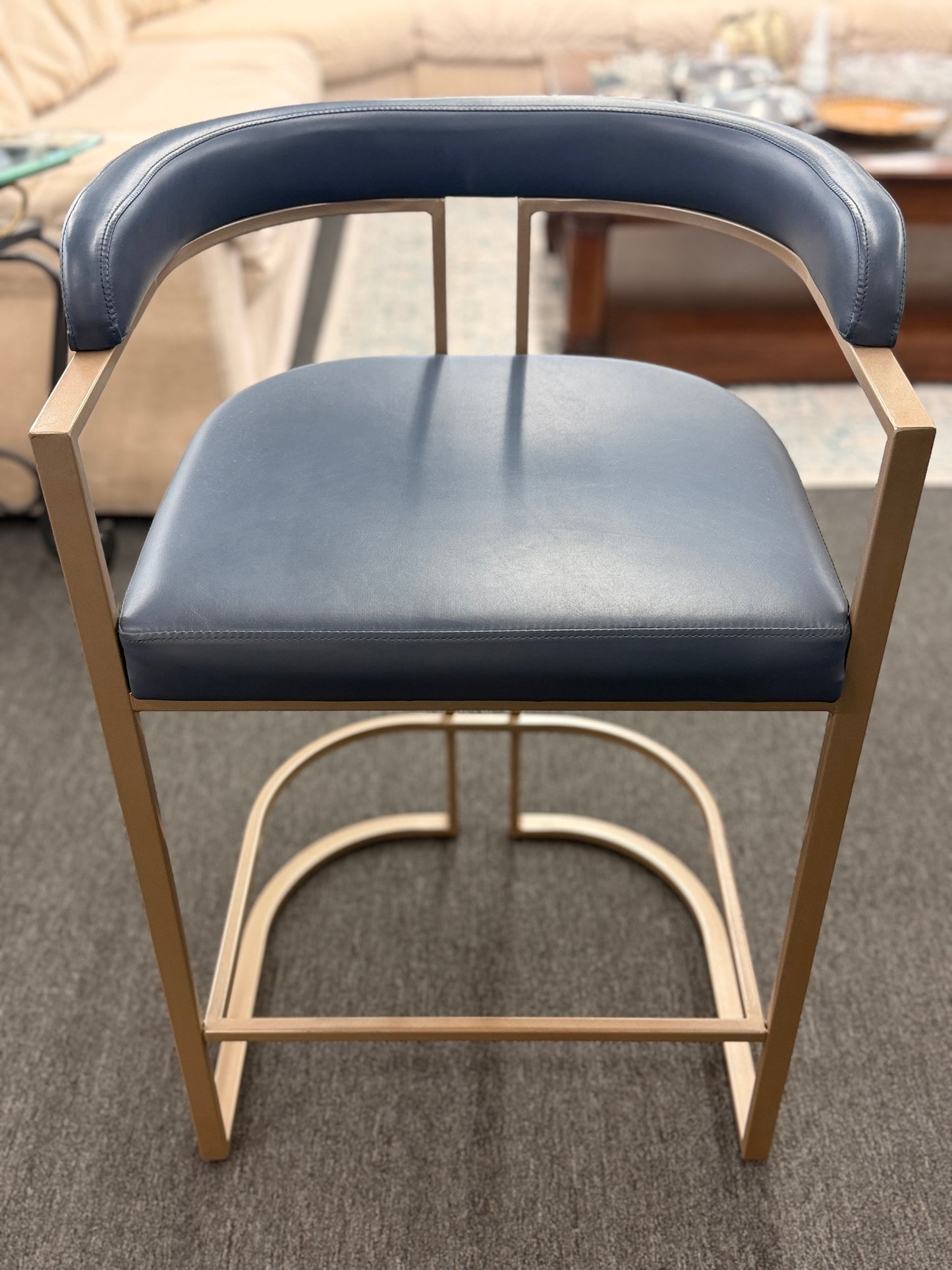 Blue cushioned chair with wooden frame on a carpeted floor