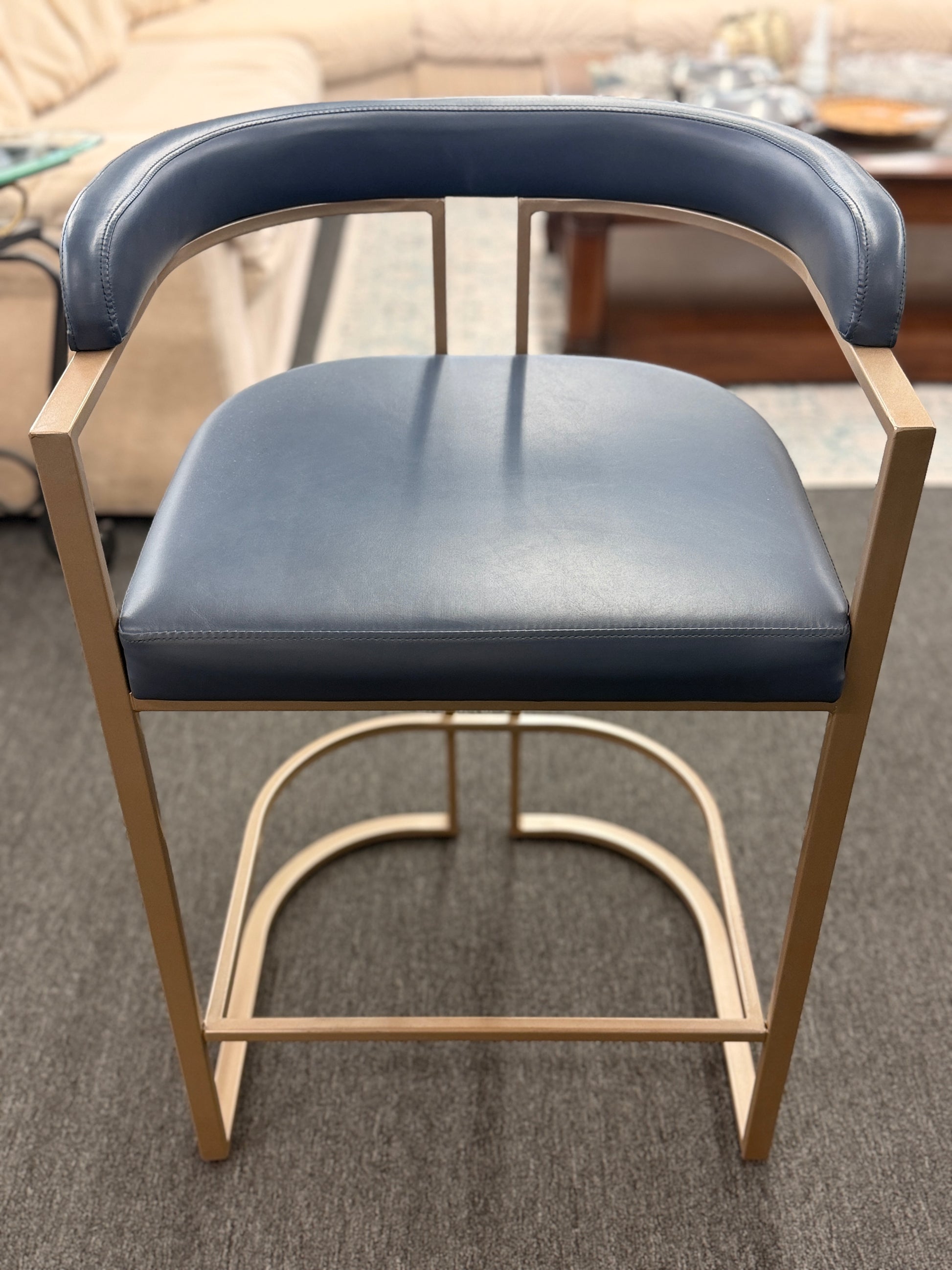 Blue cushioned chair with wooden frame on a carpeted floor