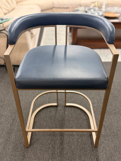 Blue cushioned chair with wooden frame on a carpeted floor