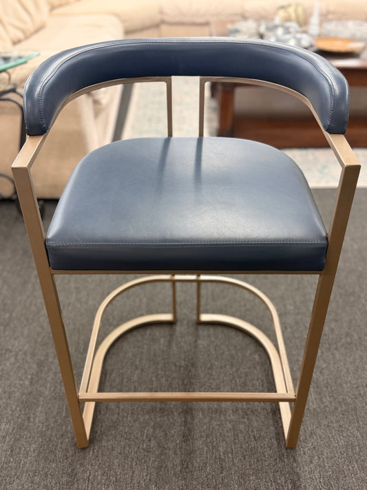 Blue cushioned chair with wooden frame on a carpeted floor