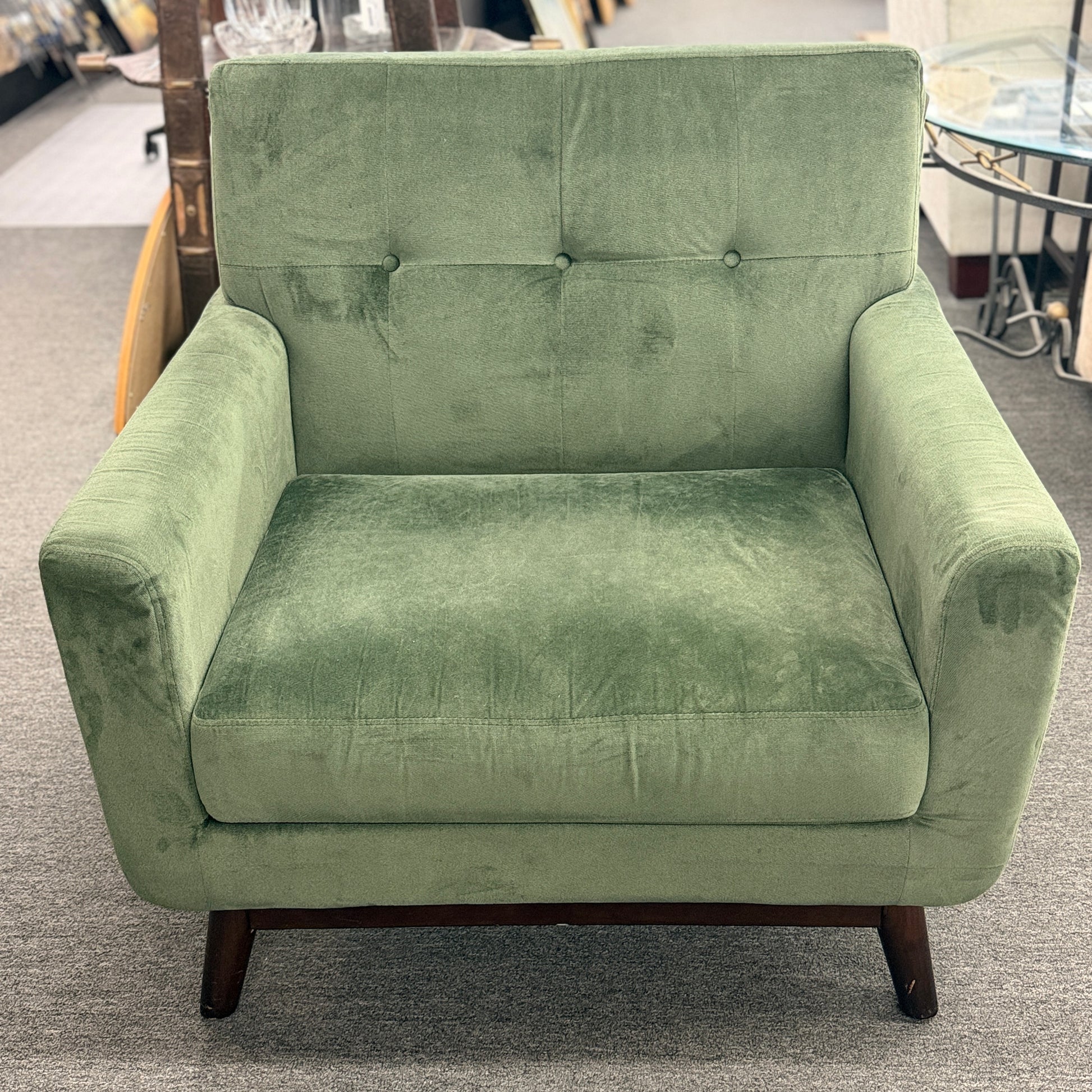 Green armchair in a room with furniture and decor.
