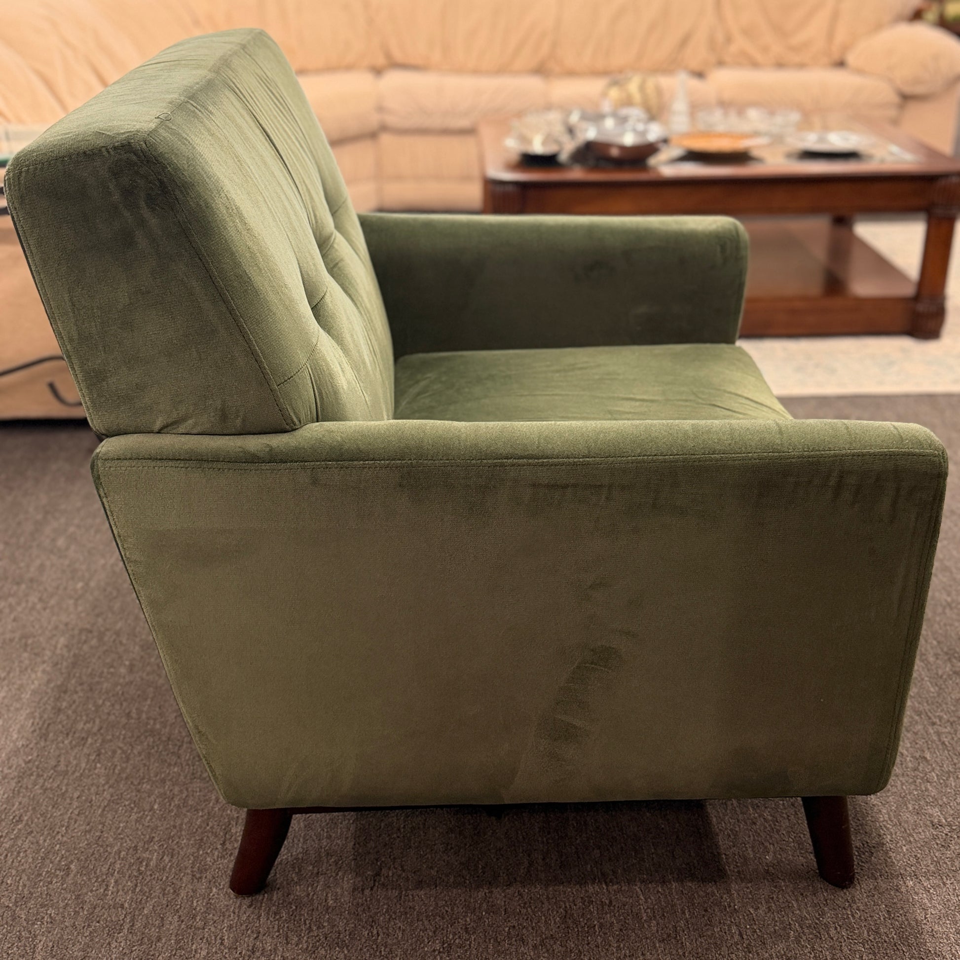 Green armchair in a living room setting with a blurred background