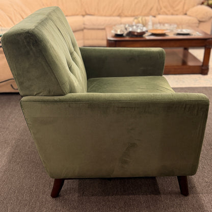 Green armchair in a living room setting with a blurred background