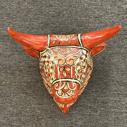 Decorative wall piece with bull head design on a gray background