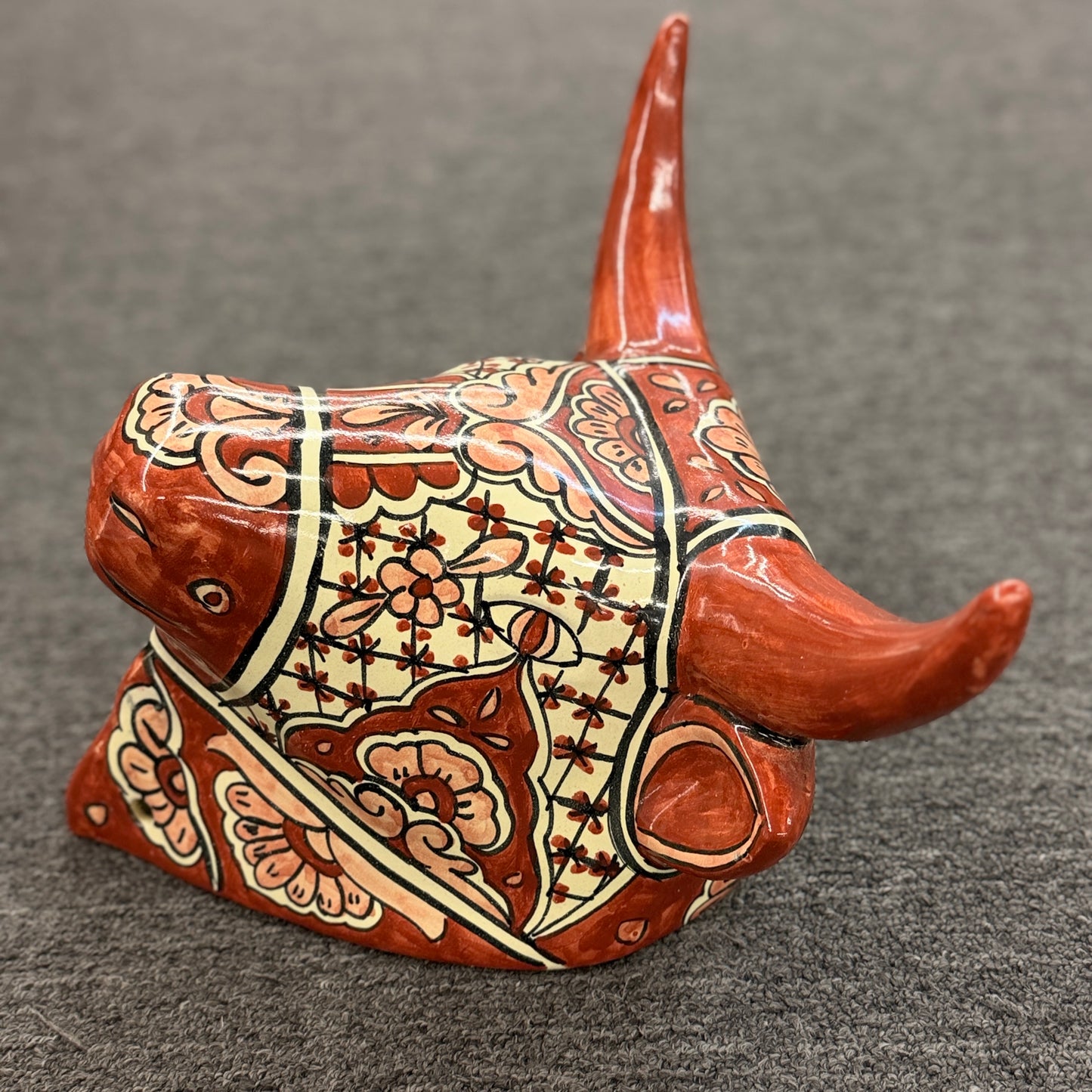 Decorative cow figurine with intricate patterns on a gray background