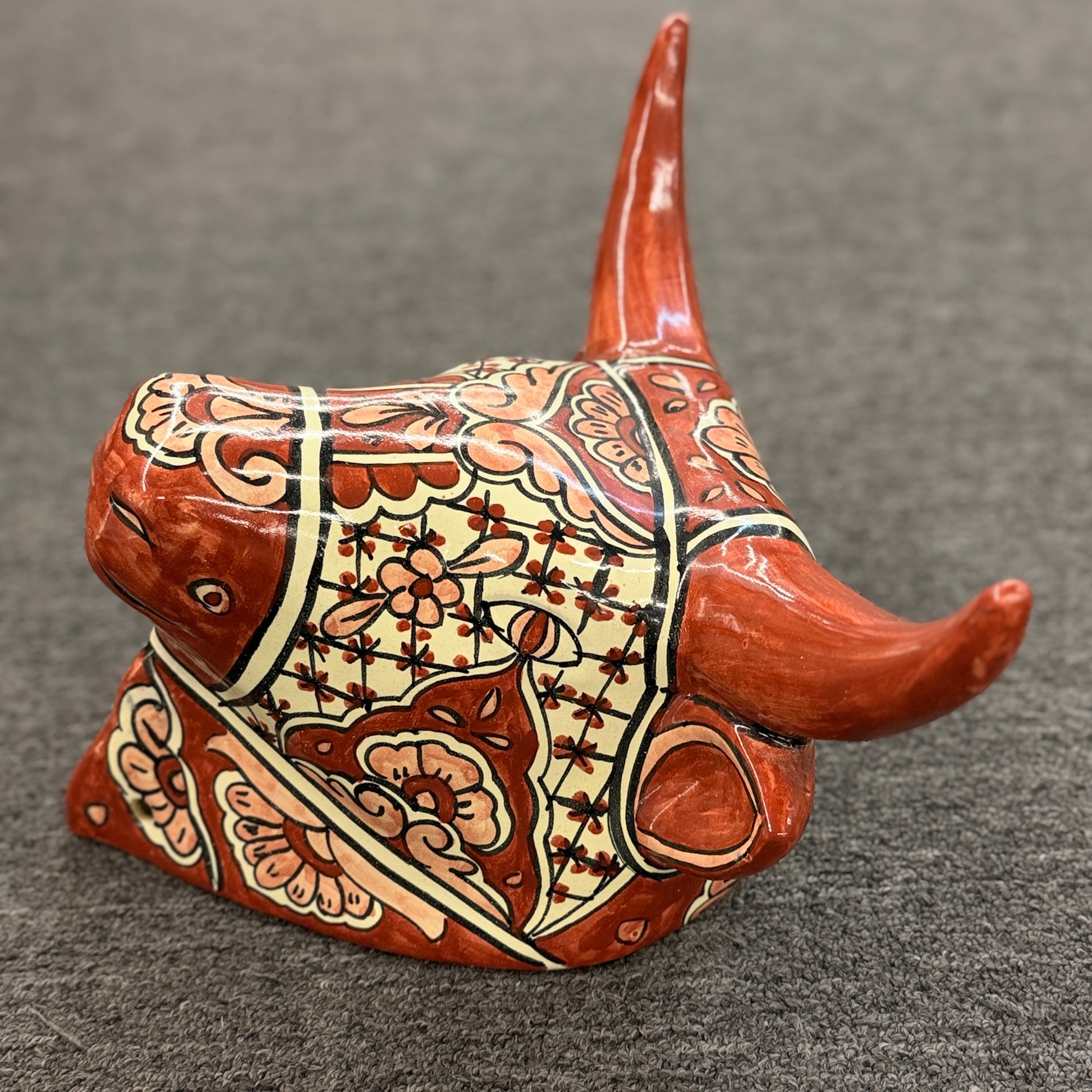 Decorative cow figurine with intricate patterns on a gray background
